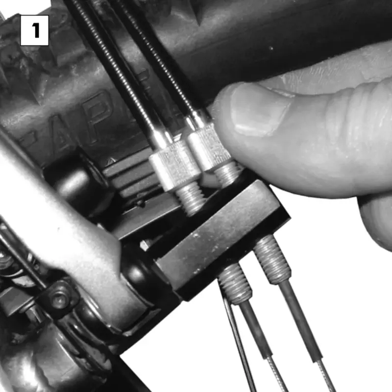 Turning the two cable adjusters on the Rohloff cable box to set the shift cable tension.
