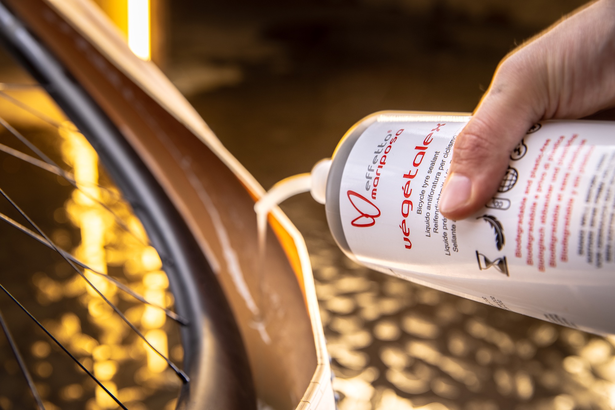 A cyclist checking and inflating a tubeless bike tire to prevent tire pressure dropping