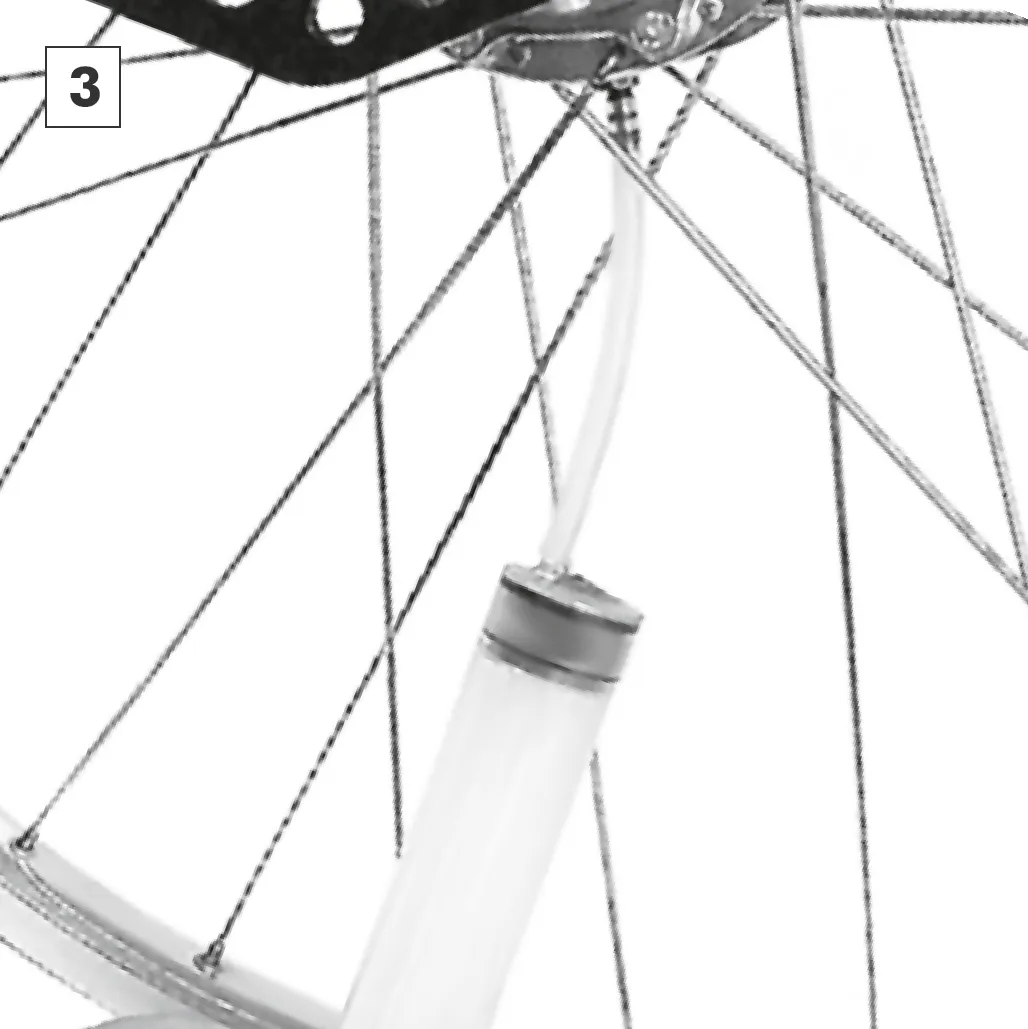 Drawing off the old oil with the syringe, with the drain opening pointing downwards.